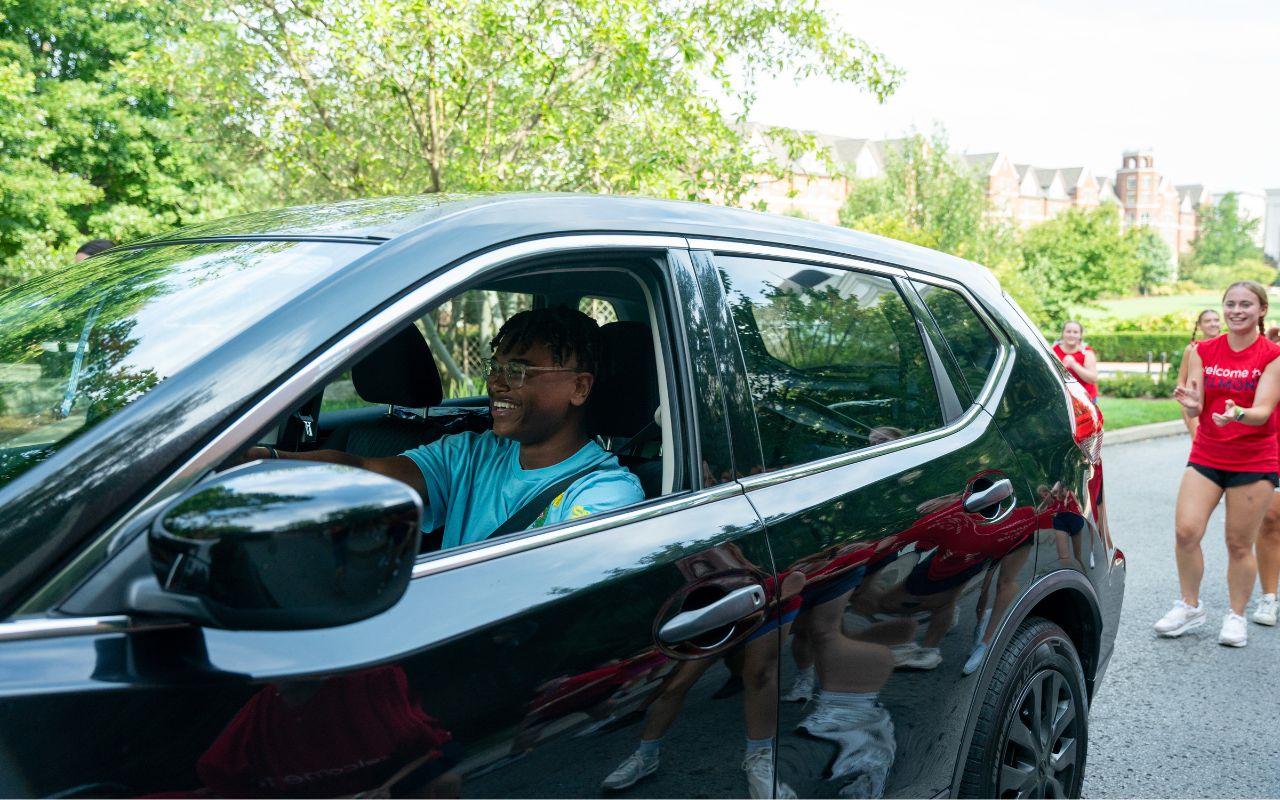 A parent smiles at Towering Traditions leaders during move-in