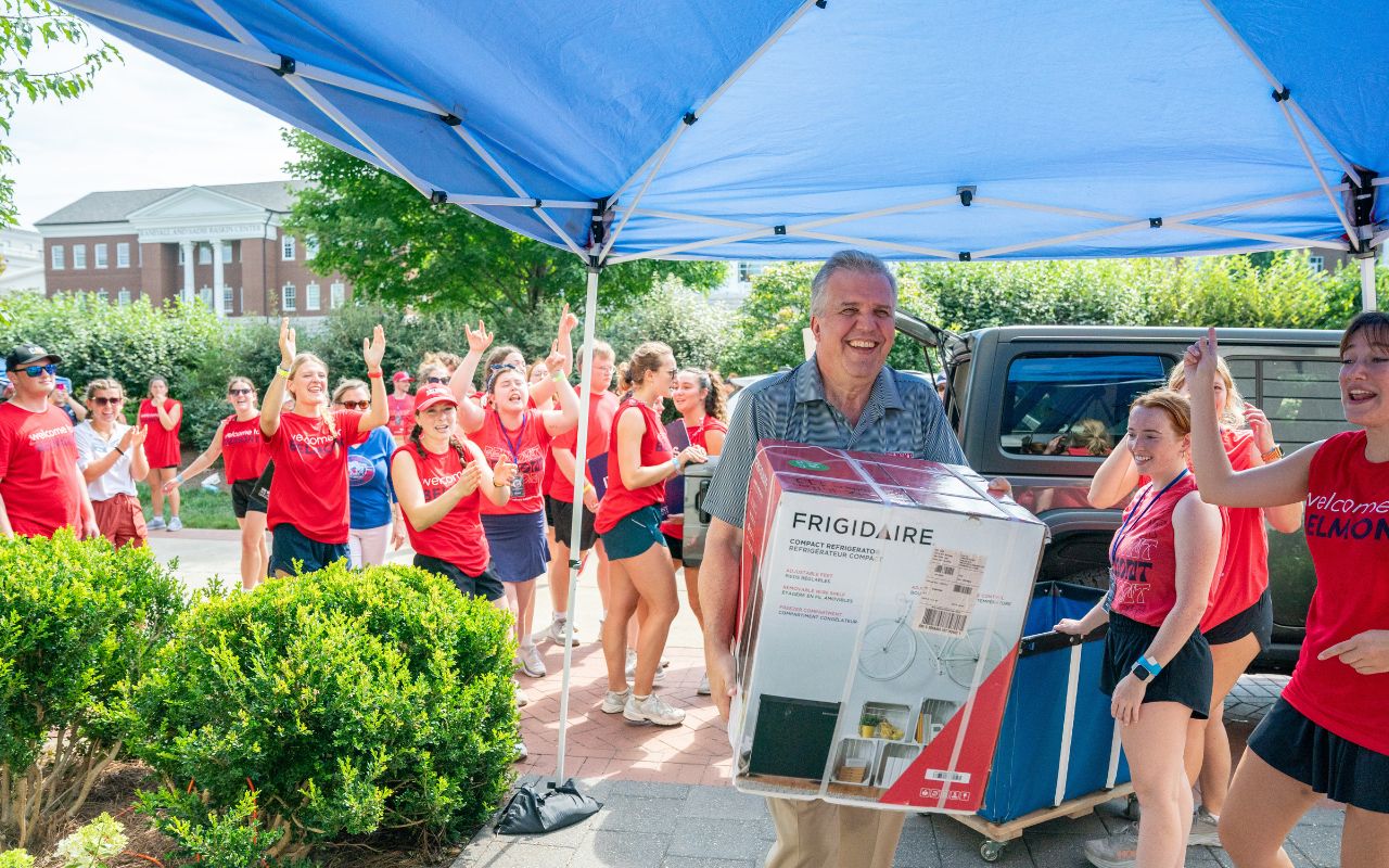 President Greg Jones helps new students move into their new residence halls