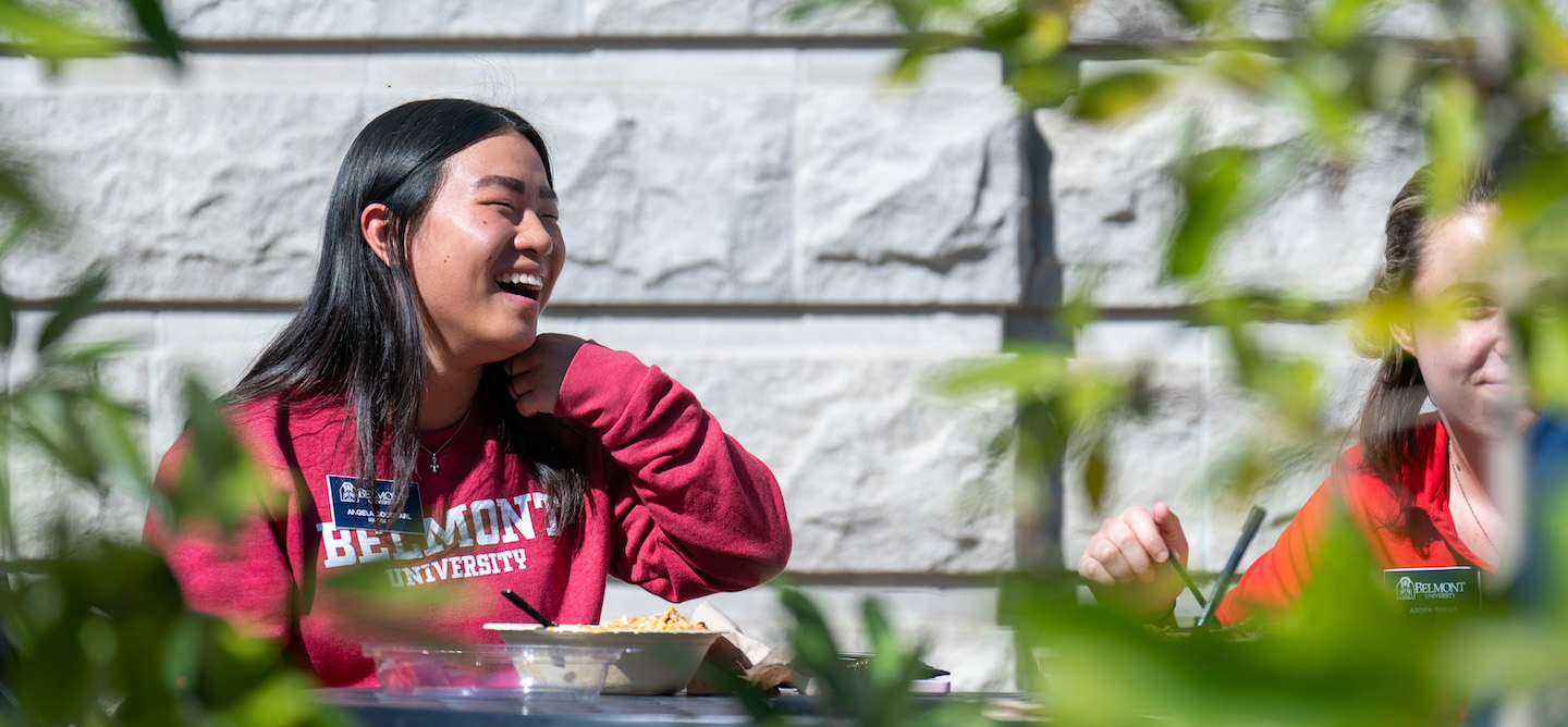 Staff member at a table with a Belmont shirt