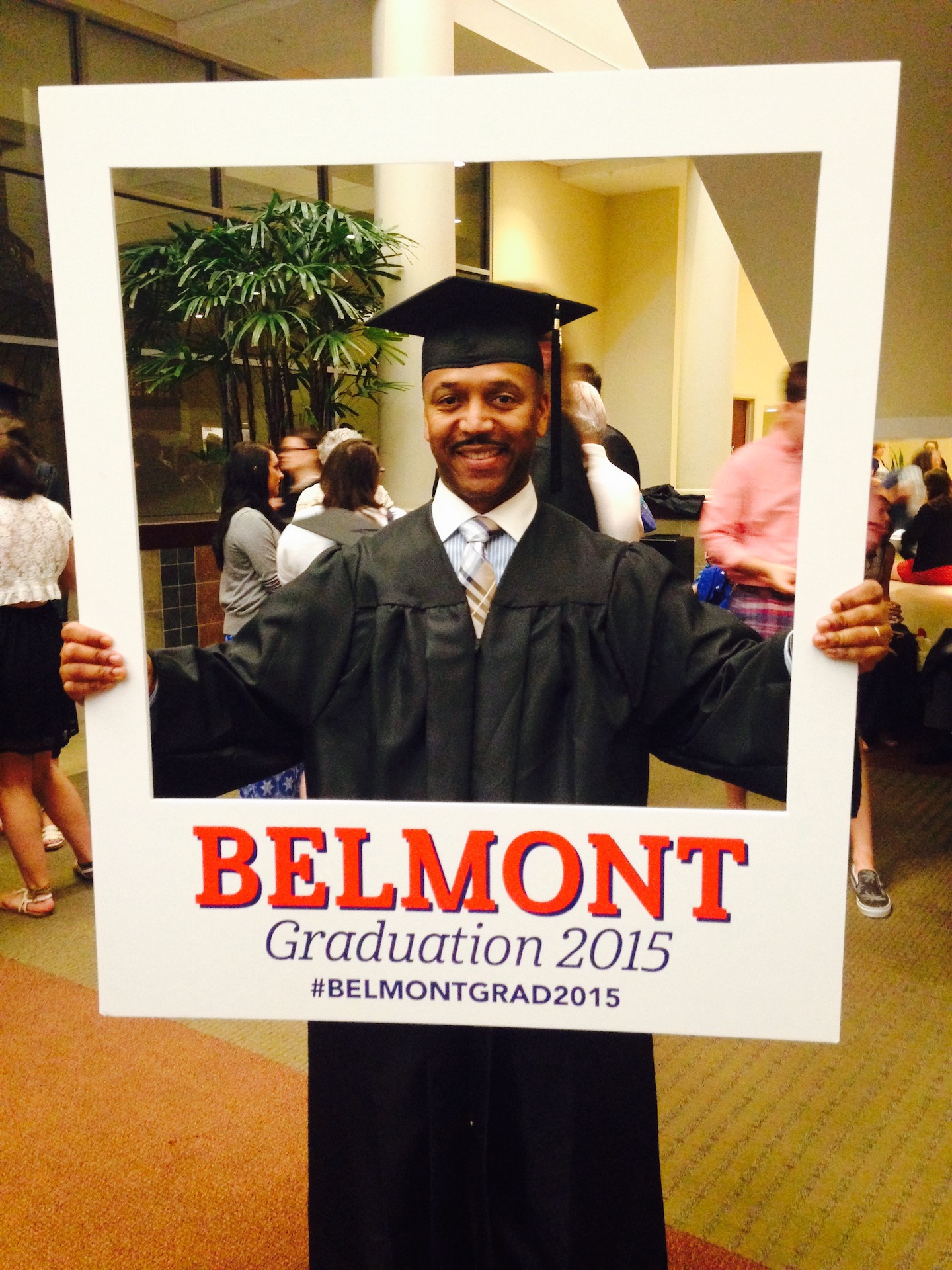 Sidney holding up a graduation sign with the year 2015