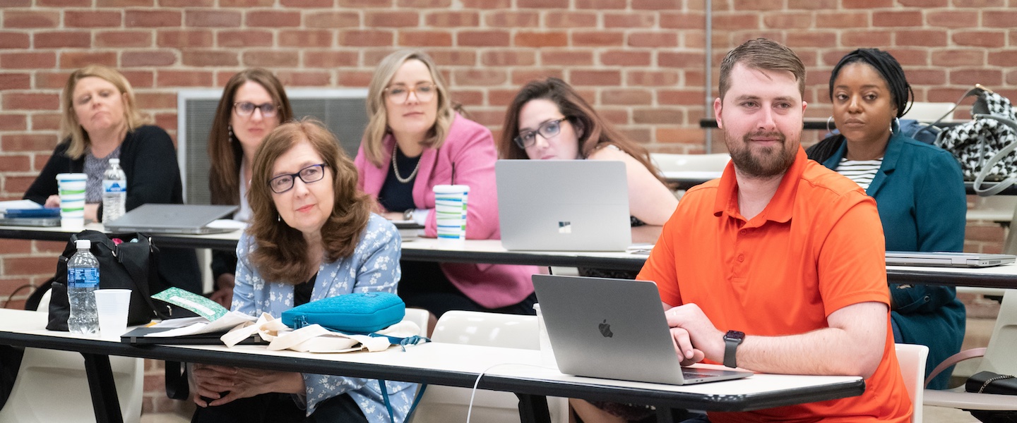 student in orange shirt for online-graduate-educational-leadership-courses