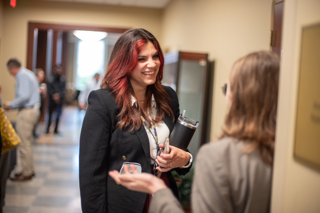 Woman smiling and networking at symposium