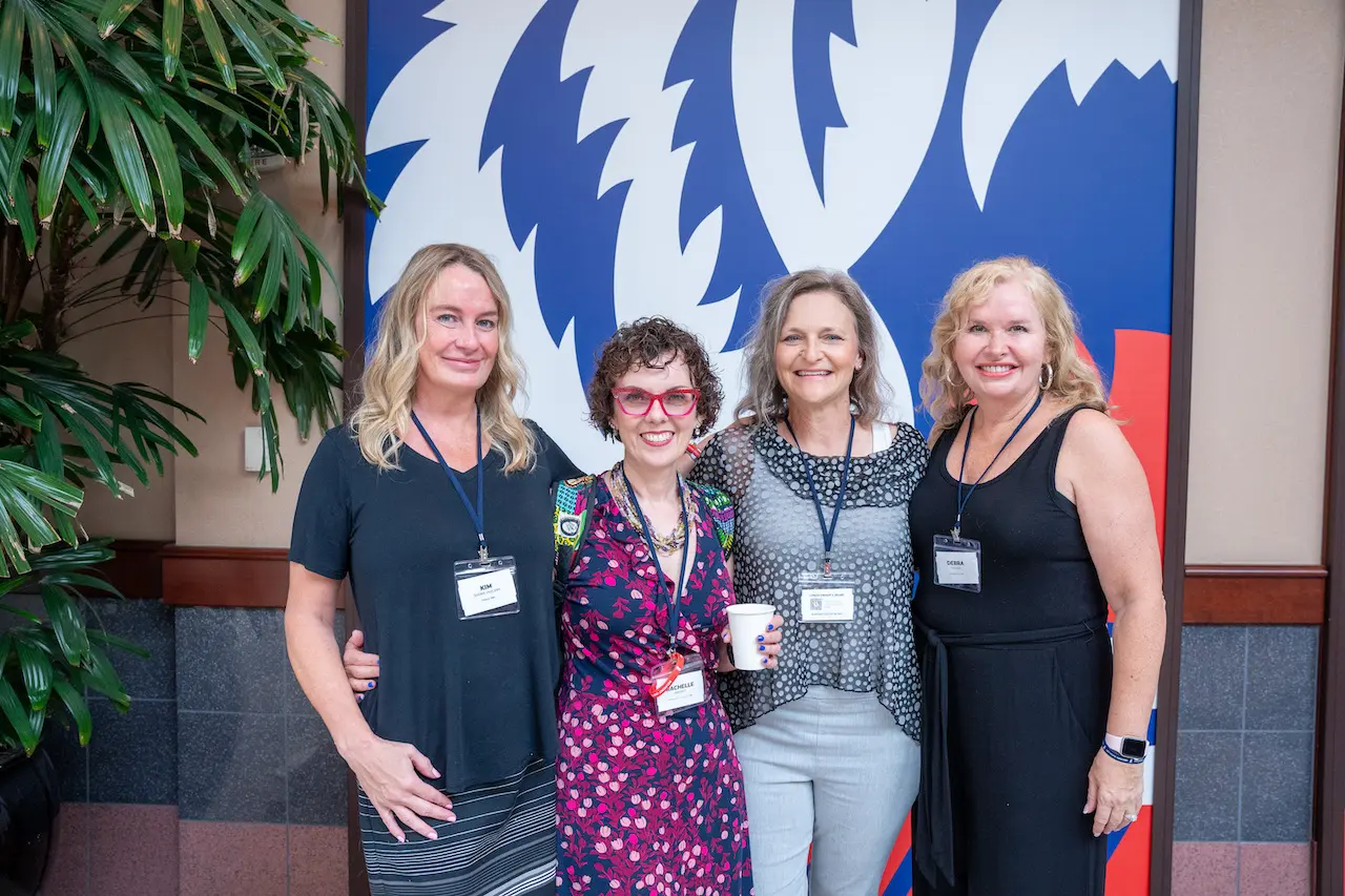 Four alumna pose for picture
