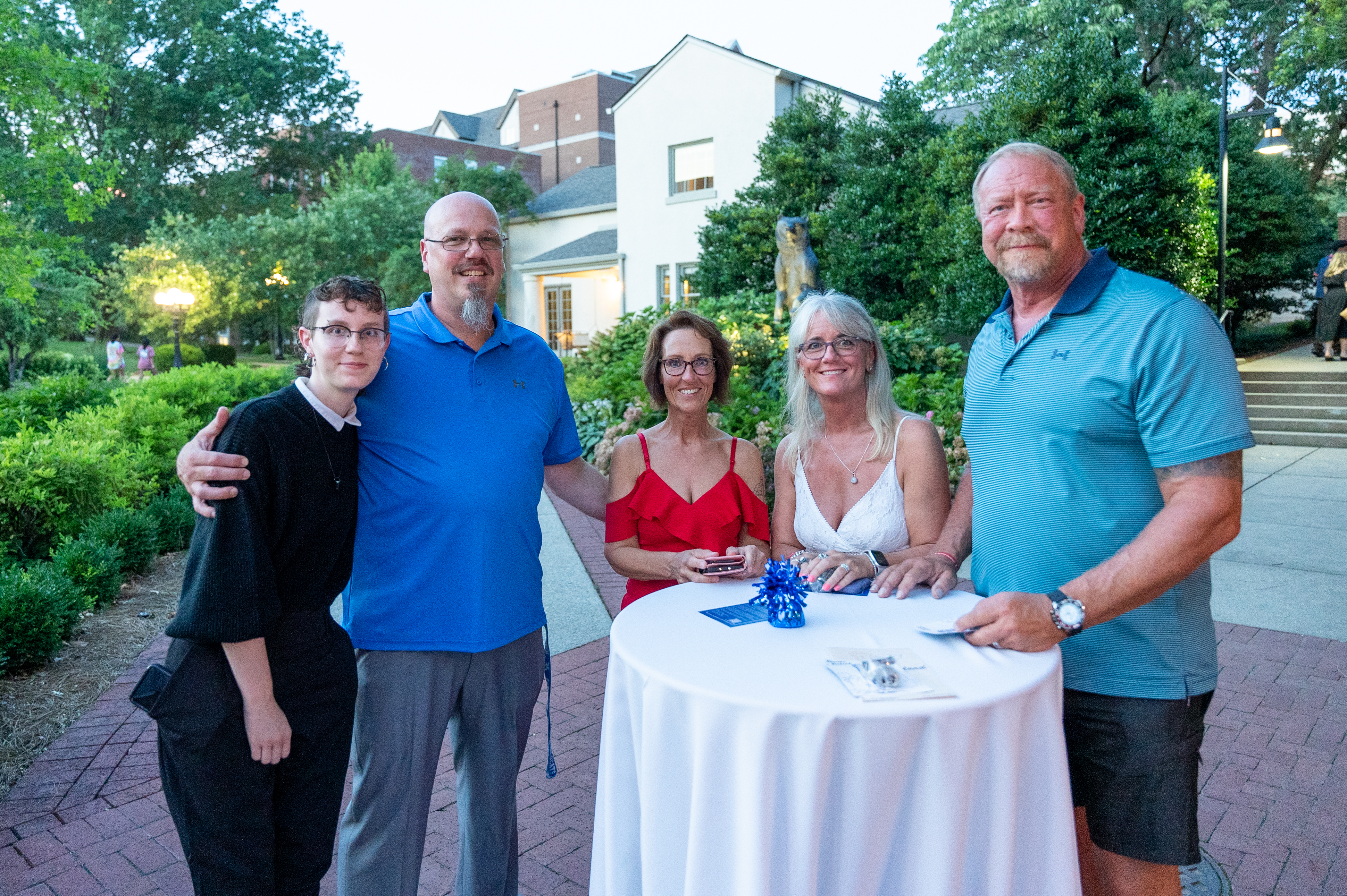 Group of people standing around table at dessert reception