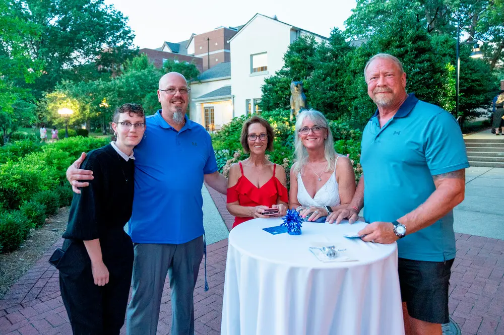 Group of people standing around table at dessert reception