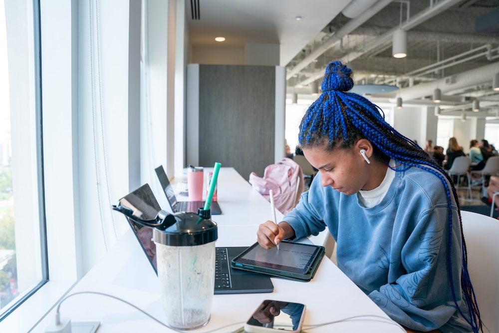 student studying with a device in Belmont's Jack C. Massey Center