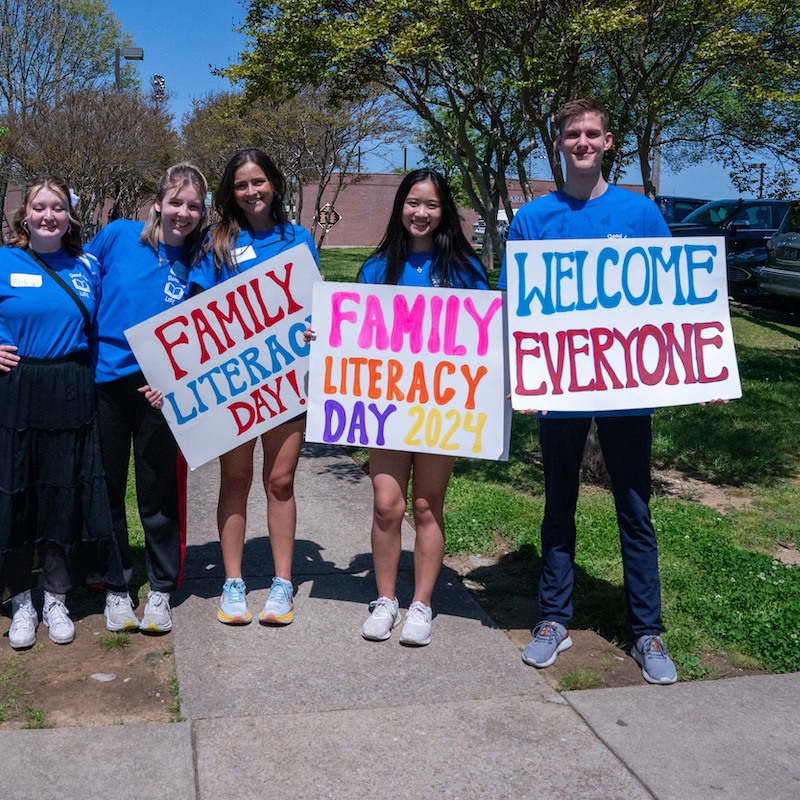 Students hold signs to promote Family Literacy Day