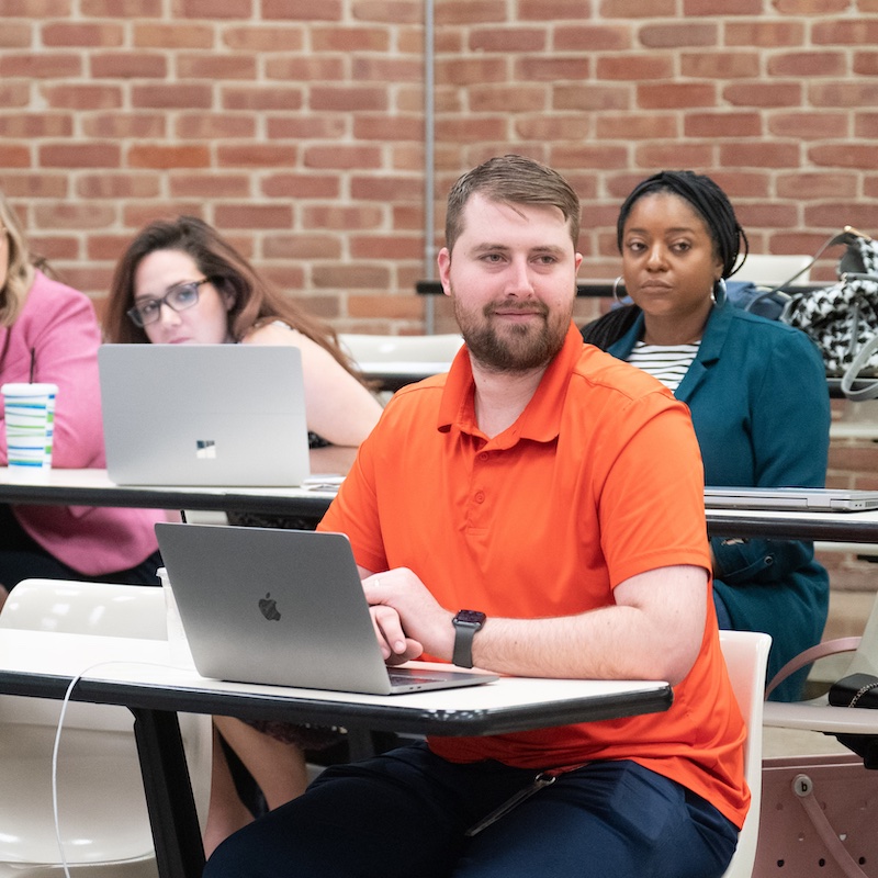 student in orange shirt for online-graduate-educational-leadership-courses