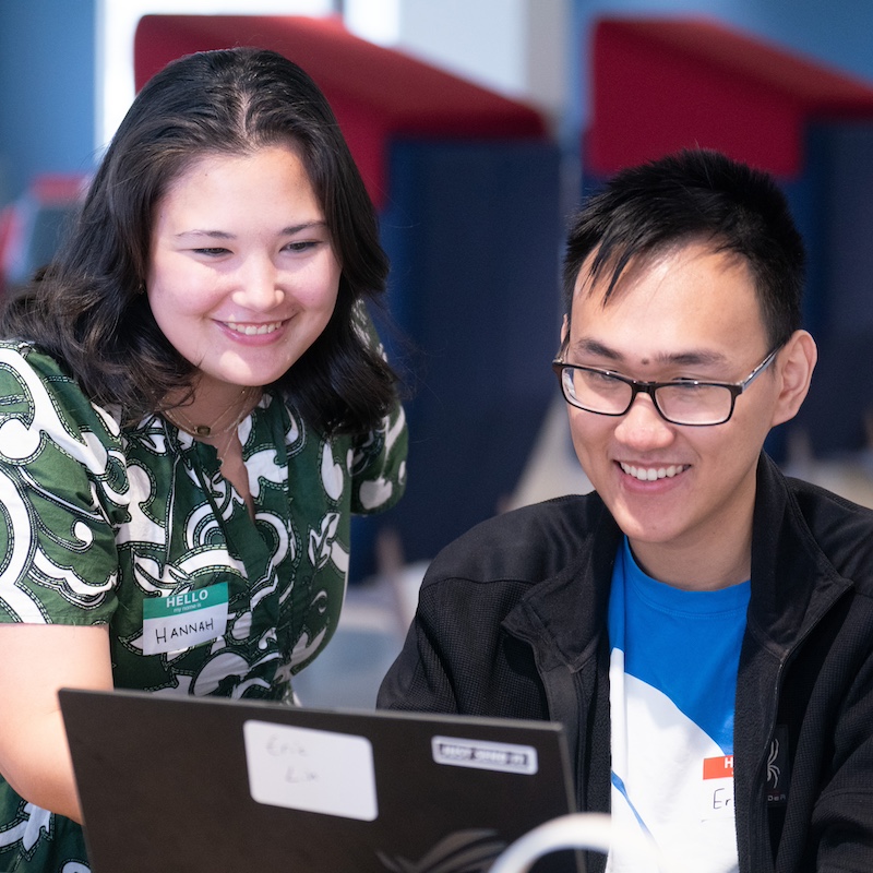 Two students looking at a laptop during the Hackathon