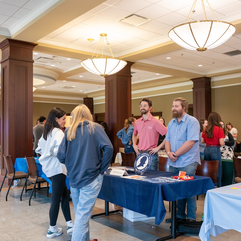 Four students standing around a table talking