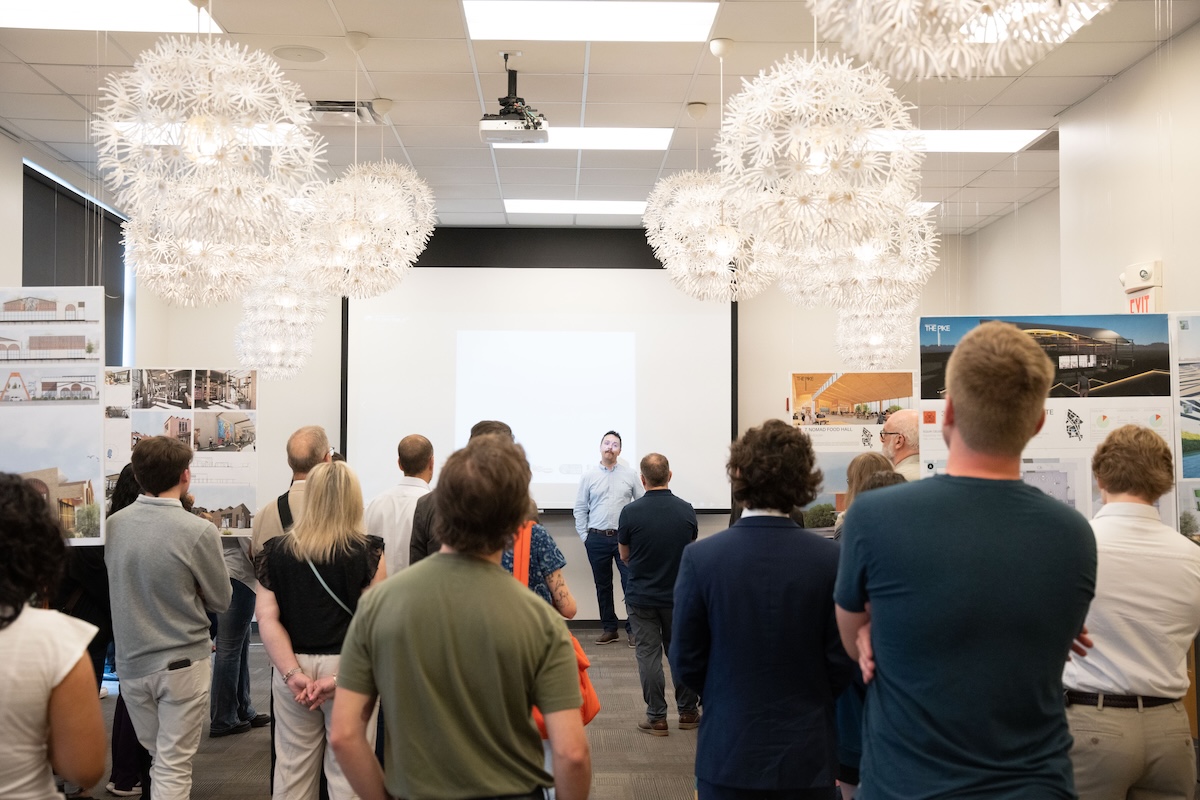 Audience members listen to a speaker during a formal presentation at the Nolensville Pike exhibit.