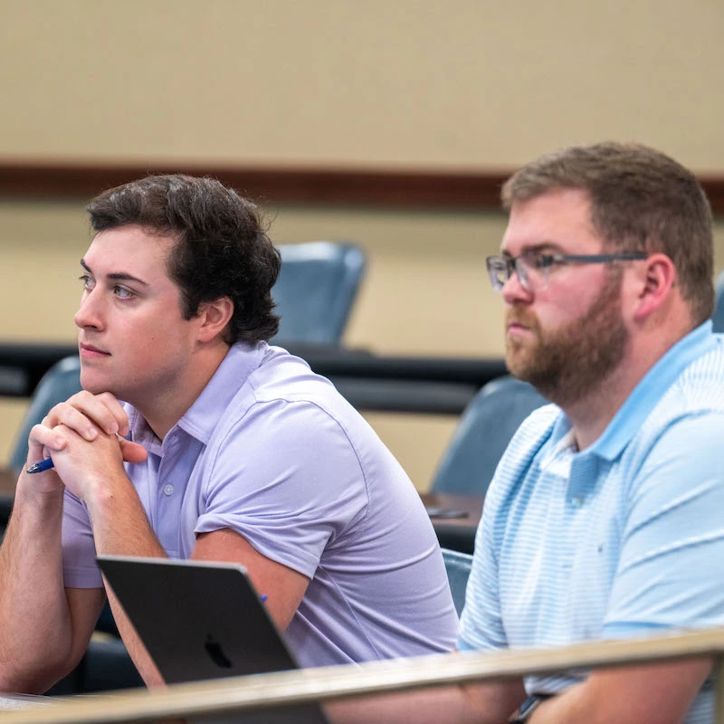 Two male law students listening in class