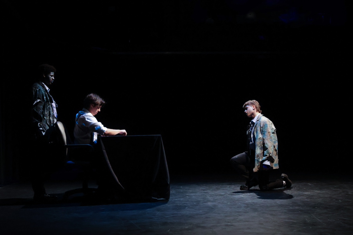 one actor kneeling far away from two others