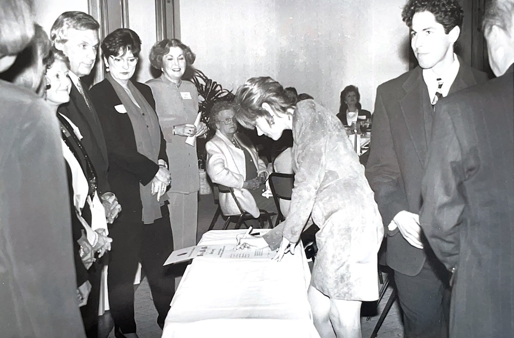 historic photo of FAB member signing a paper