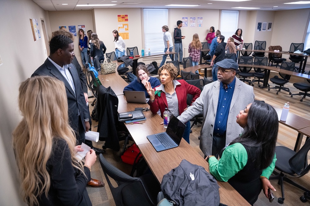 guests listen to poster presentations