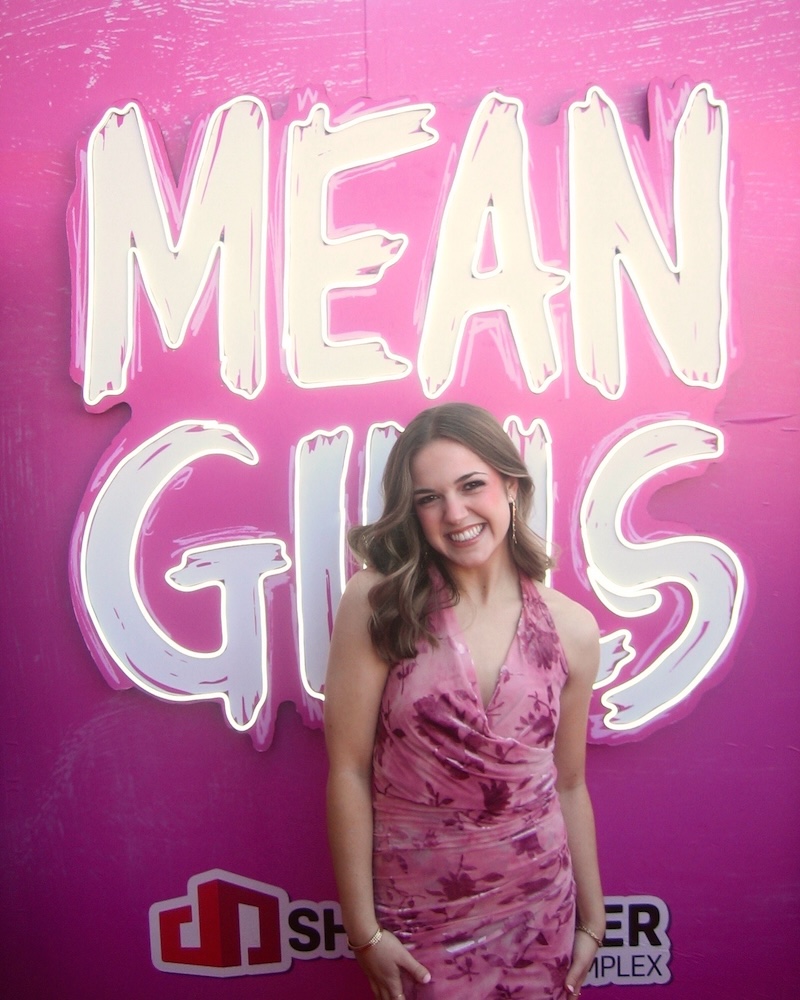 Katie Yeomans in front of a Mean Girls sign