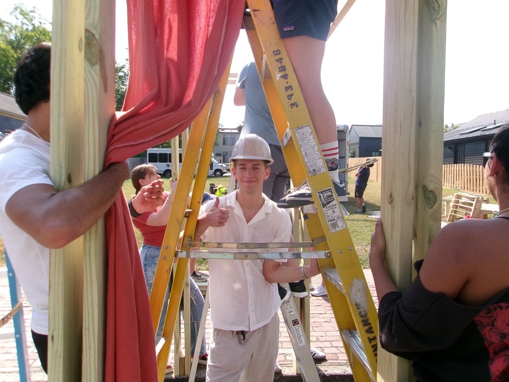 student smiles under a ladder