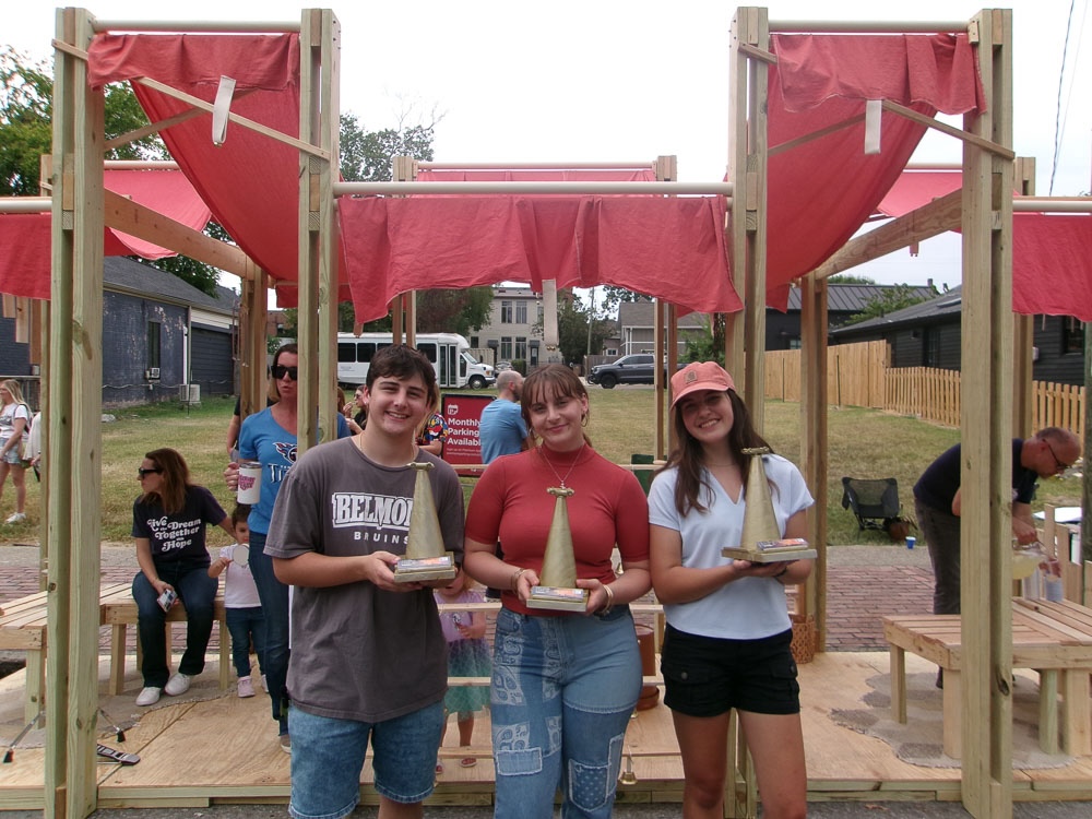 winning team stands in front of their design