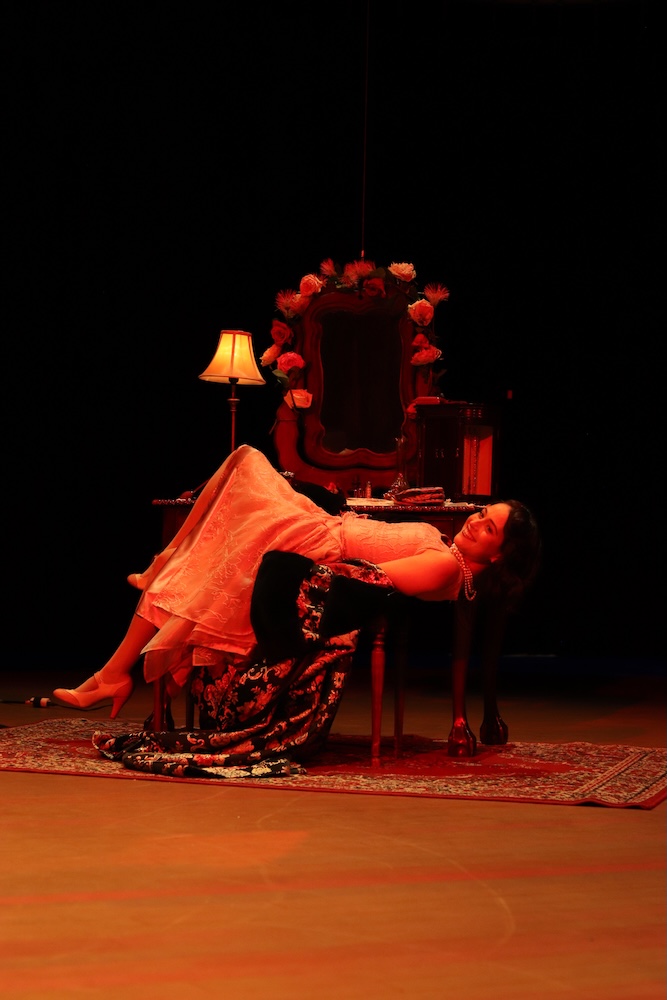 woman on stage sitting in a chair