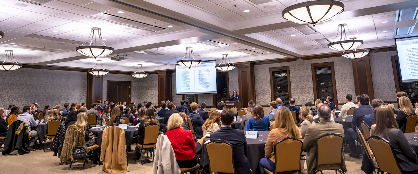 A large group of professionals and students seated at round tables during Belmont's Inns of Court. 