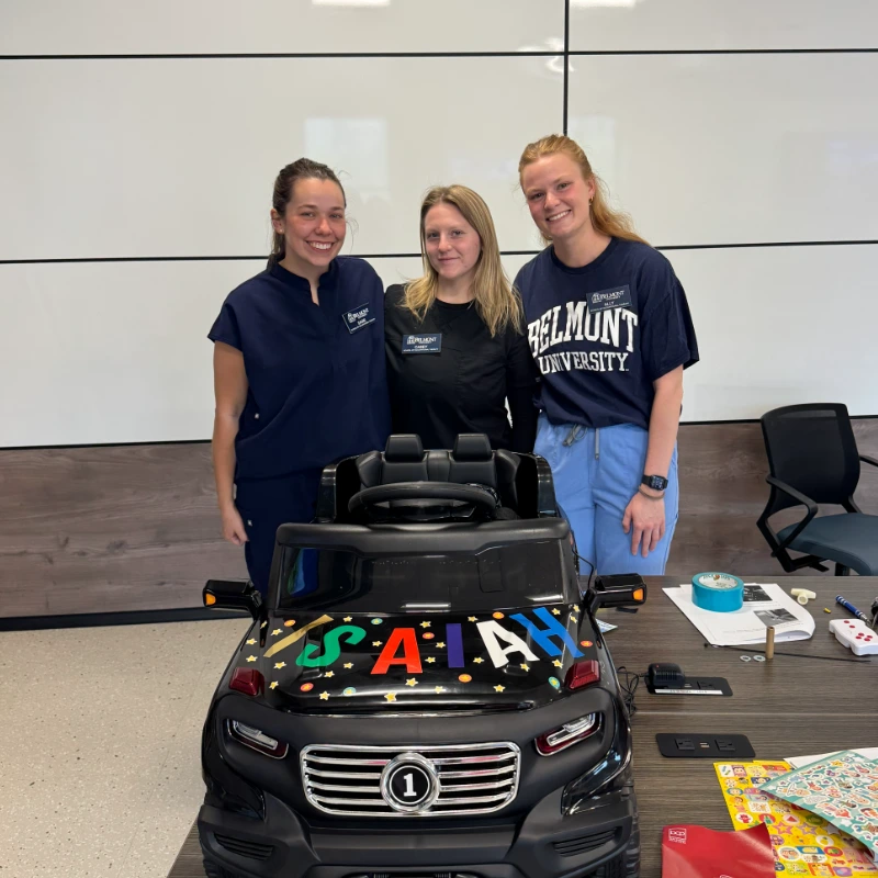 Students smiling with their modified car