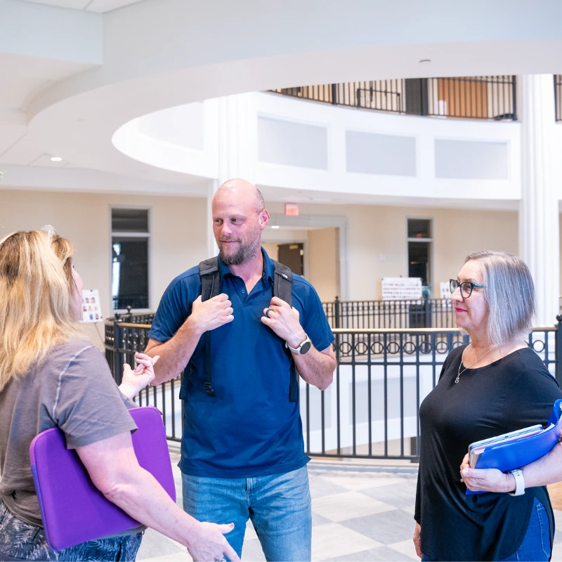 three people talking in a Belmont building