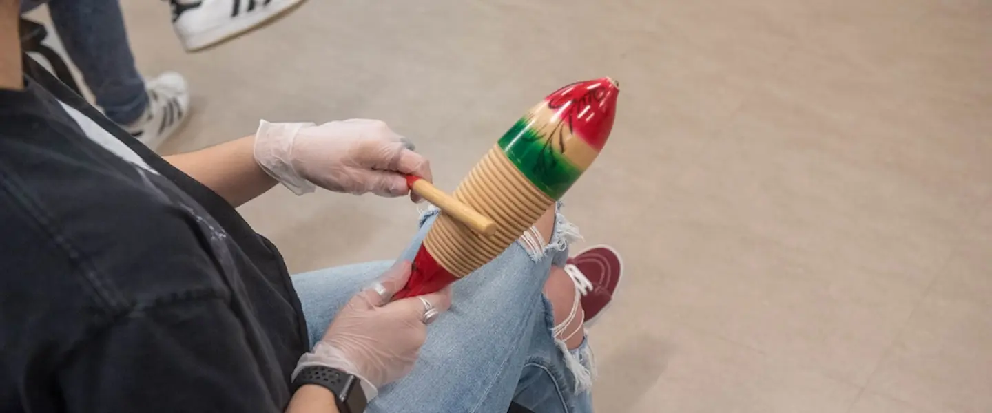someone playing a güiro instrument