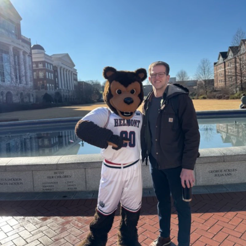 Michael Riley posing with Belmont mascot Bruiser bear