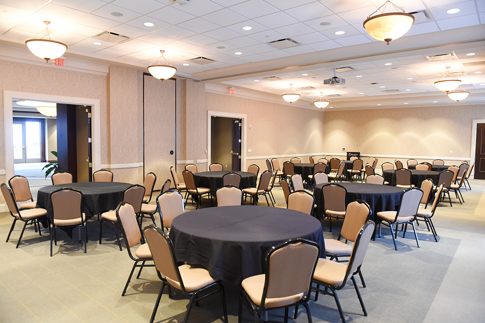 Frist Lecture Hall set up with round tables and chairs.