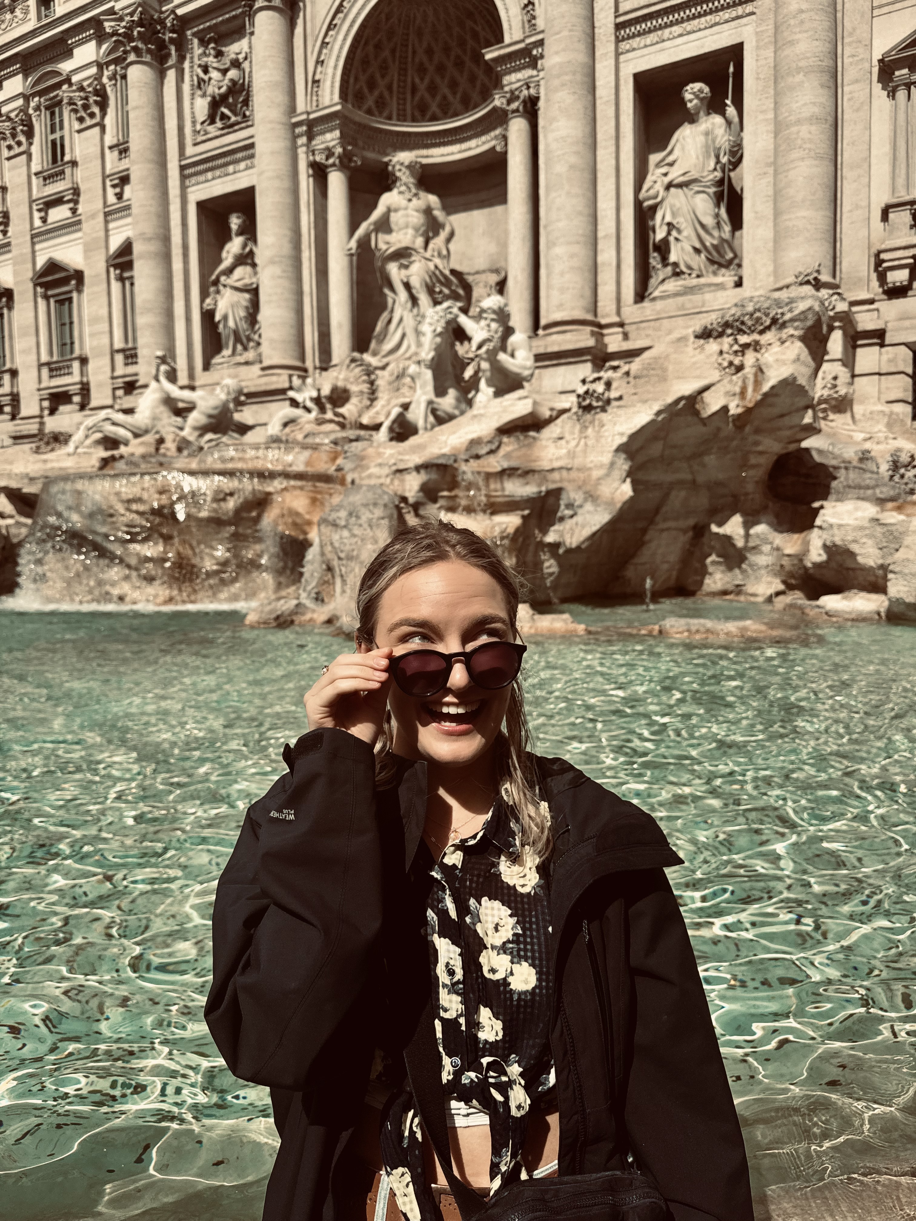 A woman, Julia, standing in front of the Trevi fountain in Rome, Italy