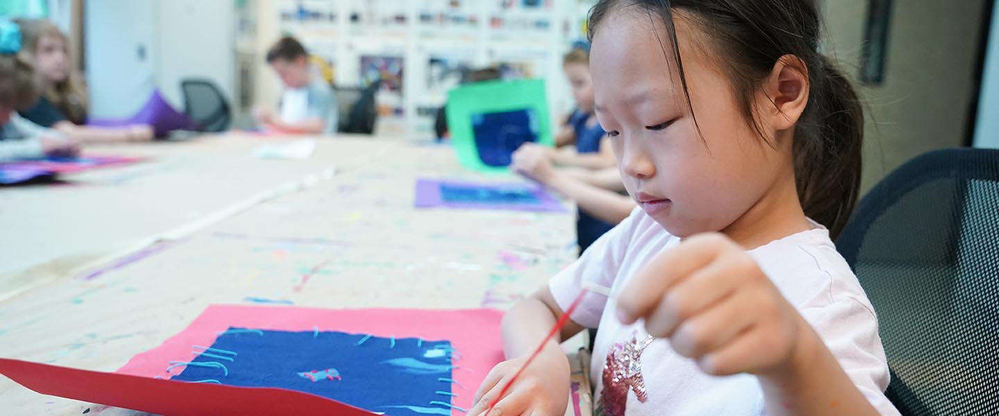 Art student from youth program focusing on an art project in a classroom