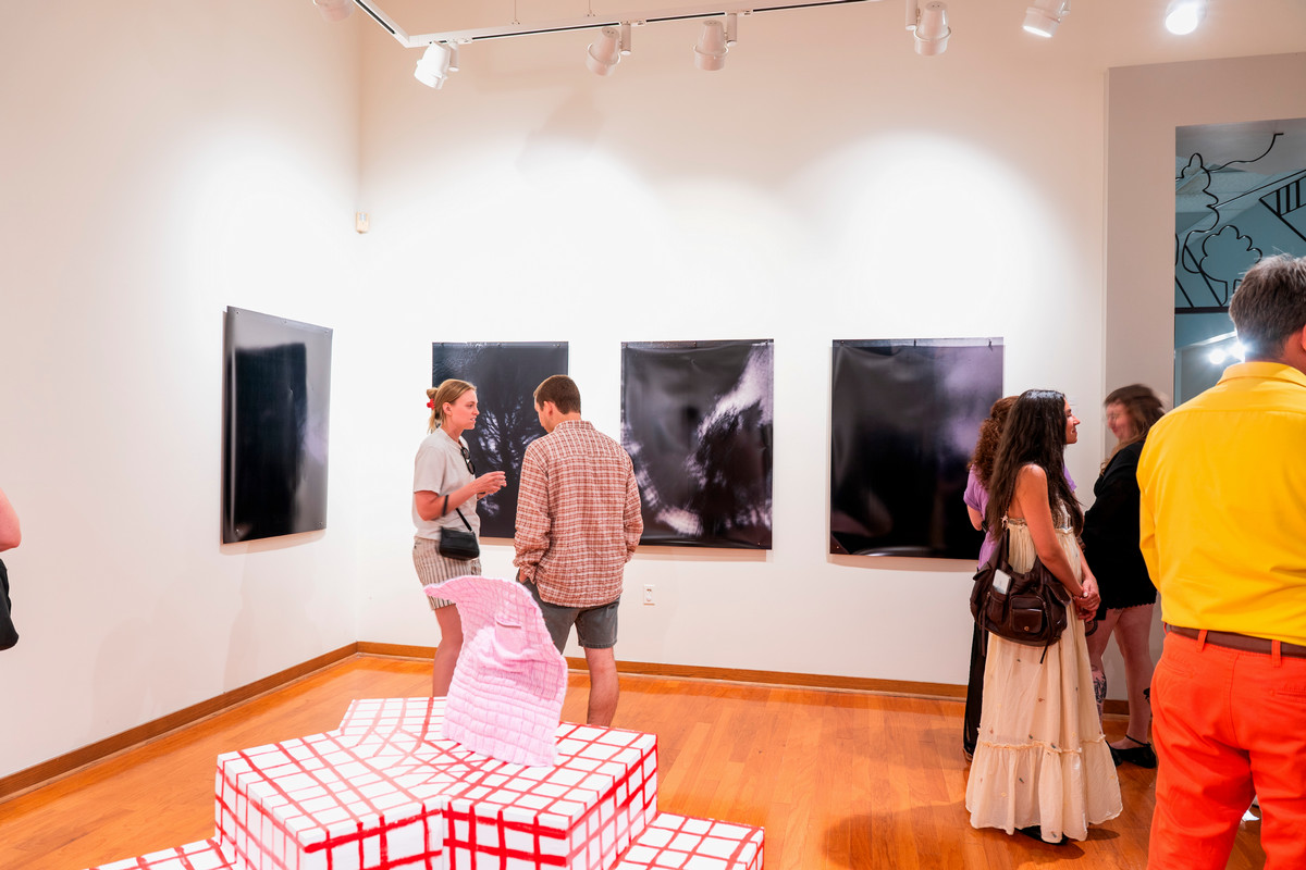 people view art and converse in a gallery