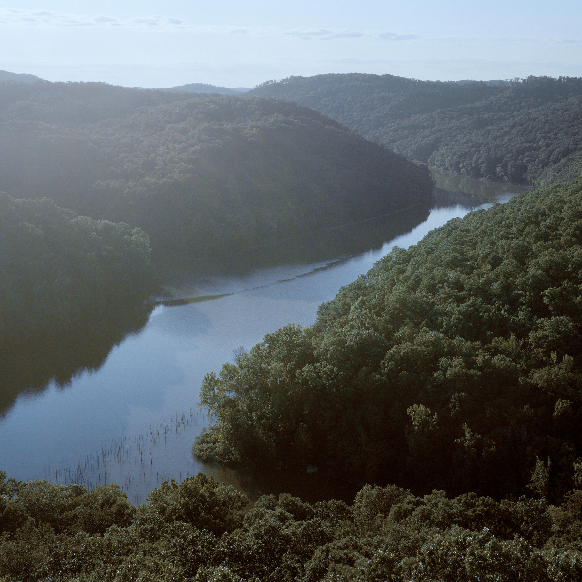a river runs through the hills covered with trees